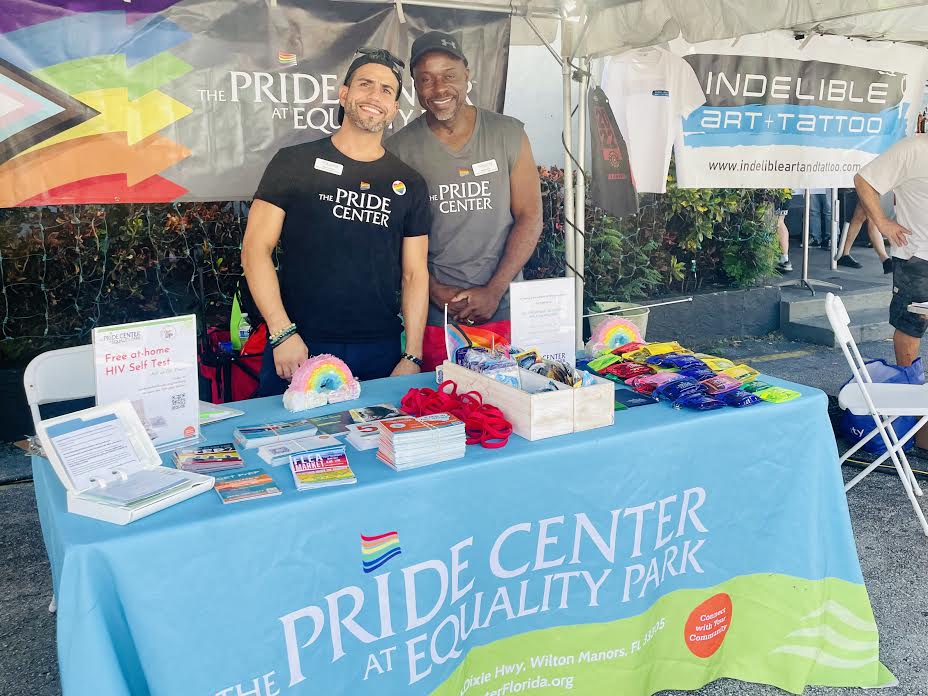 Image 1. Two of the Center staff, Dani (Bilingual Wellness Navigation Coordinator) and Malik (HIV Testing & Outreach Specialist), working an outreach table at a health fair event where the Center passed out service literature, free condoms, and free home HIV test kits. 